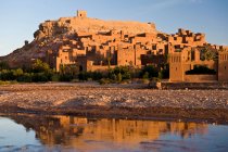 Sandstone buildings by still water — Stock Photo