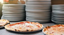 Три пиццы на тарелках — стоковое фото