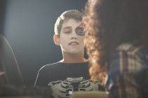 Мати малює сина скелет обличчя для Хеллоуїна — стокове фото