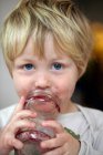 Портрет мальчика, поедающего варенье из банки — стоковое фото