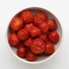 Strawberries in bowl on white — Stock Photo