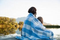 Rear view of mother and daughter wrapped in blanket — Stock Photo