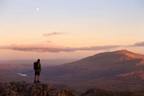 Uomo in piedi sulla cima della montagna — Foto stock