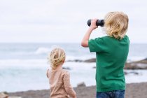 Діти, що стоять разом на пляжі — стокове фото