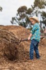 Boy using pitchfork in haystack, selective focus — Stock Photo