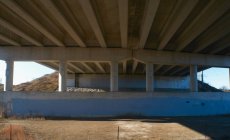 Bottom view of overpass concrete structure with pillars — Stock Photo