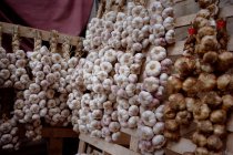 Stalks of garlic and onions for sale — Stock Photo