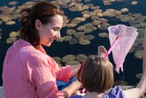 Mother and daughter fishing with net — Stock Photo
