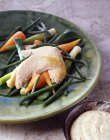 Plato de pollo al vapor sobre verduras cocidas - foto de stock