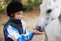 Porträt eines lächelnden Mädchens beim Ponyfüttern — Stockfoto