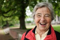 Older woman laughing in park — Stock Photo
