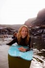 Pareja acostada en tablas de surf en el agua - foto de stock