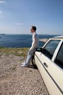 Man with oldtimer overlooking sea — Stock Photo