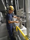 Travailleur utilisant des machines dans l'usine — Photo de stock