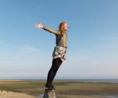 Woman standing on wooden post — Stock Photo