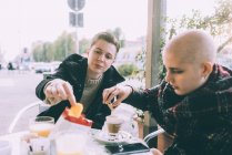 Deux femmes amies mangeant des collations au café du trottoir — Photo de stock