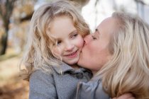 Mutter küsst Tochter im Freien — Stockfoto