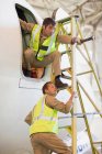 Trabalhadores de aeronaves em escada — Fotografia de Stock