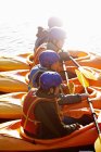 Kayakers rowing together on still lake — Stock Photo