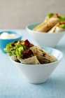 Tortilla wraps in bowls on blue table — Stock Photo