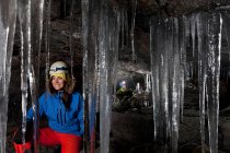 Escursionista con ghiaccioli in grotta glaciale — Foto stock