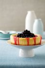 Cheesecake with dark cherries on cakestand — Stock Photo