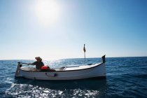 Рыбак на рыбацкой лодке в море — стоковое фото