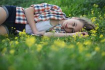 Жінка лежить на полі квітів — стокове фото