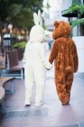 People in bunny and bear costumes at street — Stock Photo