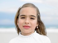 Nahaufnahme Porträt eines Mädchens am Strand, das in die Kamera blickt — Stockfoto