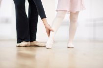 Балерина и учитель практикуют точку на ноге — стоковое фото