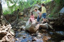 Діти на скелях біля річки — стокове фото