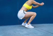 Giovane donna che si esercita all'aperto, facendo squat — Foto stock