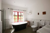 Salle de bain avec baignoire près de la fenêtre — Photo de stock