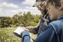 Hiking father and teenage son reading map, Cody, Wyoming, USA — Stock Photo