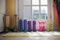 Tidy row of rubber boots at back door — Stock Photo