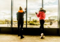 Zwei Freundinnen blicken aus dem Fenster — Stockfoto