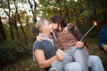 Ältere Paare küssen sich mit Wunderkerzen — Stockfoto
