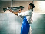 Fishmonger face to face with fish — Stock Photo
