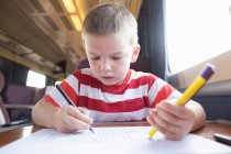 Мальчик рисует в поезде — стоковое фото