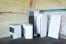 Discarded fridges and freezers placed near wall — Stock Photo