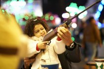 Father helping daughter with rifle at shooting gallery at funfair — Stock Photo