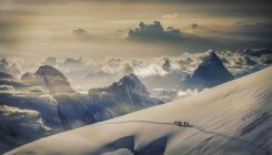 Escaladores lejanos en glaciar, Alpes, Cantón de Berna, Suiza - foto de stock