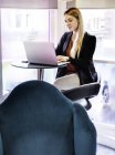 Geschäftsfrau tippt im Büro auf Laptop — Stockfoto