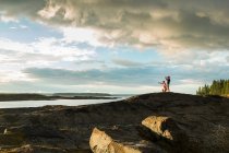 Vista à distância de homem e filho idosos olhando através de binóculos na costa do Maine, EUA — Fotografia de Stock