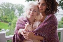 Seniorin und Tochter umarmen sich auf Veranda, Porträt — Stockfoto