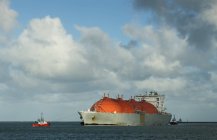 Petrolero de gas que entra en el puerto con la ayuda de remolcador - foto de stock