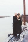 Couple étreignant sur le front de mer du canal brumeux — Photo de stock
