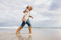 Couple marchant dans la mer — Photo de stock