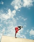 Baixo ângulo de visão do jovem skate no ar — Fotografia de Stock
